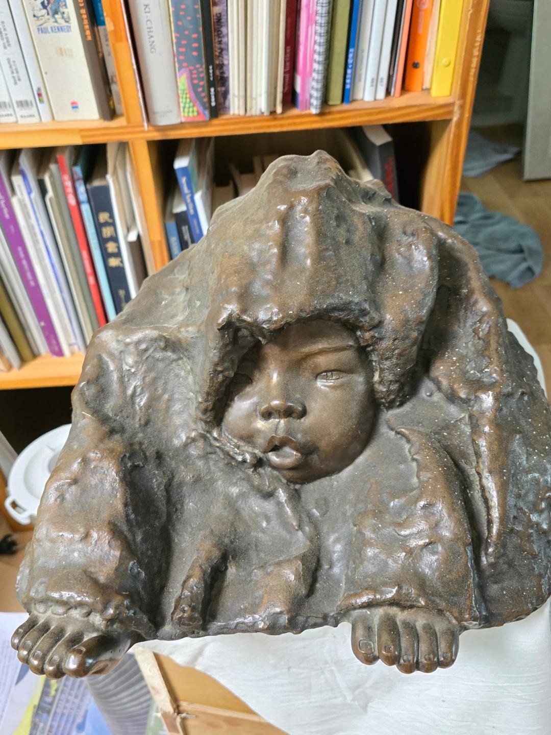 강희덕, 〈겨울 아이〉, 브론즈, 21x35x37cm — 두건 달린 두툼한 옷 속에서 얼굴을 내민 아이