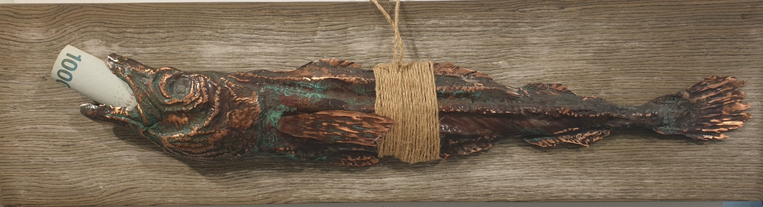 손금식, 〈환생〉, 목재 동판, 600x150cm — 낡은 나무 널판 위에 구리빛 물고기가 걸리고 입에 지폐가 물려 있다